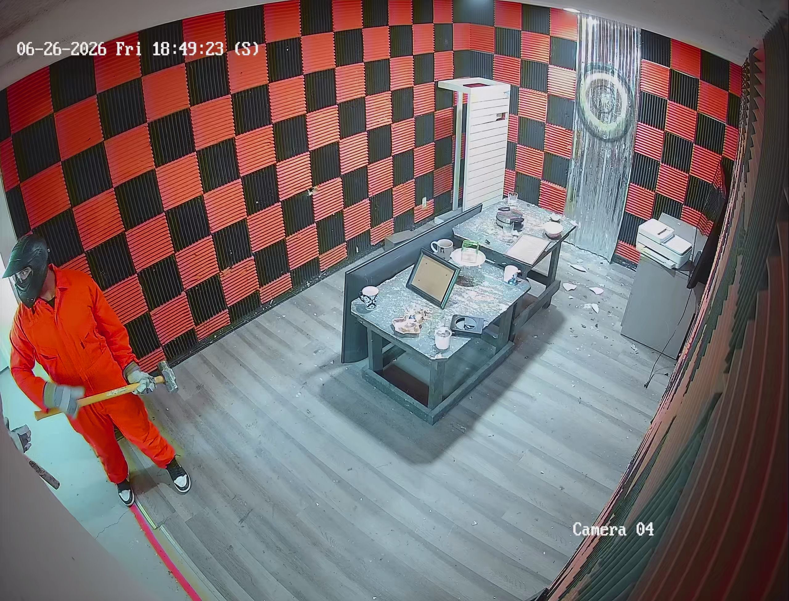 Security camera view of guest smashing electronics in Crash Out rage room